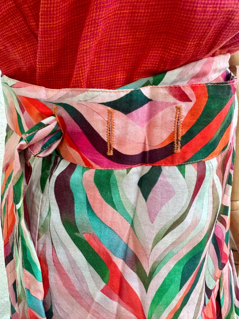 Jupe porte-feuille Thérèse multicouleurs. Cette jupe a été réalisé dans un atelier de Jaipur qui est de taille humaine et où les valeurs humaines et le respect sont une priorités pour le directeur. La production de cet article est une série limitée. En achetant cet article vous contribuez à une mode originale, authentique et durable. Ainsi, vous consommez autrement pour une mode plus lente, plus juste. Détail des encoches pour les différentes tailles.