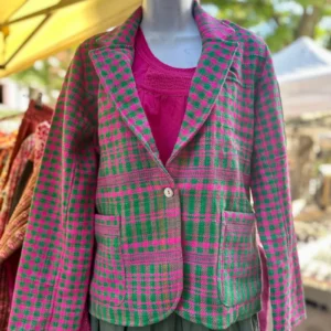Le spencer Thar en 100% laine du Rajasthan, de couleur rose fluo et vert. Le tissu est à l'origine un châle d'homme en laine et est tissé artisanalement sur des métiers à tisser. Le tissu intérieur est imprimé au tampon en bois à la main et est en 100% coton.Le spencer a été réalisé dans un atelier de Jaipur qui est de taille humaine et où les valeurs humaines et le respect sont une priorités pour le directeur. La production de cet article est une série limitée. En achetant cet article vous contribuez à une mode originale, authentique et durable. Ainsi, vous consommez autrement pour une mode plus lente, plus juste. Détail de l'avant.